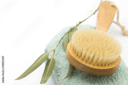 Dry body massage wooden eco brush on the towel on white background . Tool for smooth and soft skin Home spa. Close up. Space for text