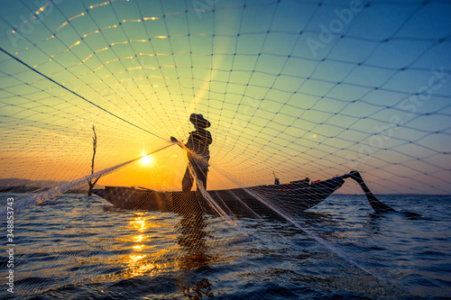 Fototapeta Naklejka Na Ścianę i Meble -  Fisherman net sunset Silhouette boat