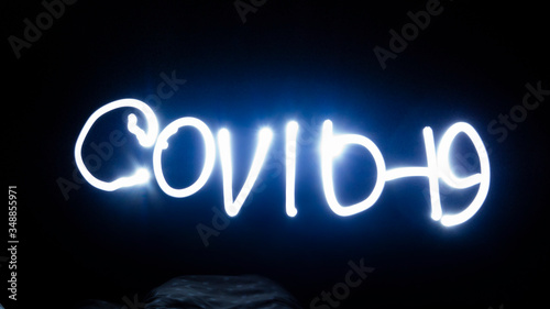 lettering with covid - 19 light at night at high exposure (freezelight)