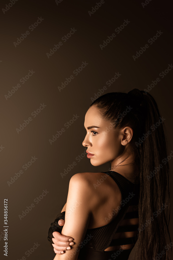 Fototapeta premium Attractive sportswoman in sportswear isolated on black
