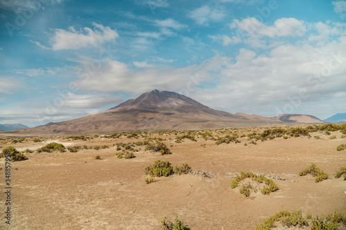 Dry, barren landscape mountain background. Dramatic desert, snowcapped mountains wilderness. Mountain range view. Salt Flats of Uyuni, Bolivia. Copy space, blue sky, nature, hiking, and sand dust