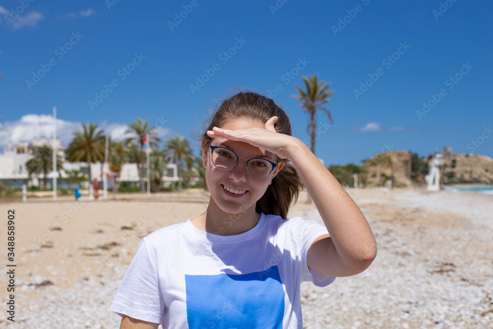 Closeup portrait of a beautiful young Caucasian fashion model posing outdoor in sunny weather at sea
