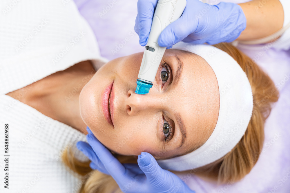 Serene female patient during the microdermabrasion treatment Serene female patient during the microdermabrasion treatment
