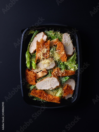 Caesar salad in plastic box for take away, from above