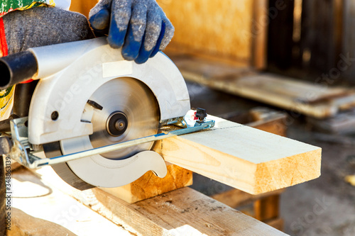 Manual circular circular saw on wood metabo. A man at a construction site saws a wooden Board bar close-up. The concept of working with wood on a sawmill. Woodworking equipment.