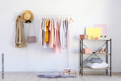 fashionable clothes on a rack in a bright interior of the wardrobe room