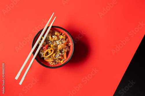 asian cuisine: noodles with seafood and veggies on red and background. horizontal. menu design template with space for text