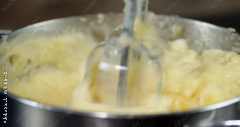 Mashed potatoes in a pot whisk it with a mixer. Mashed potatoes in a pot whisk it with a mixer.