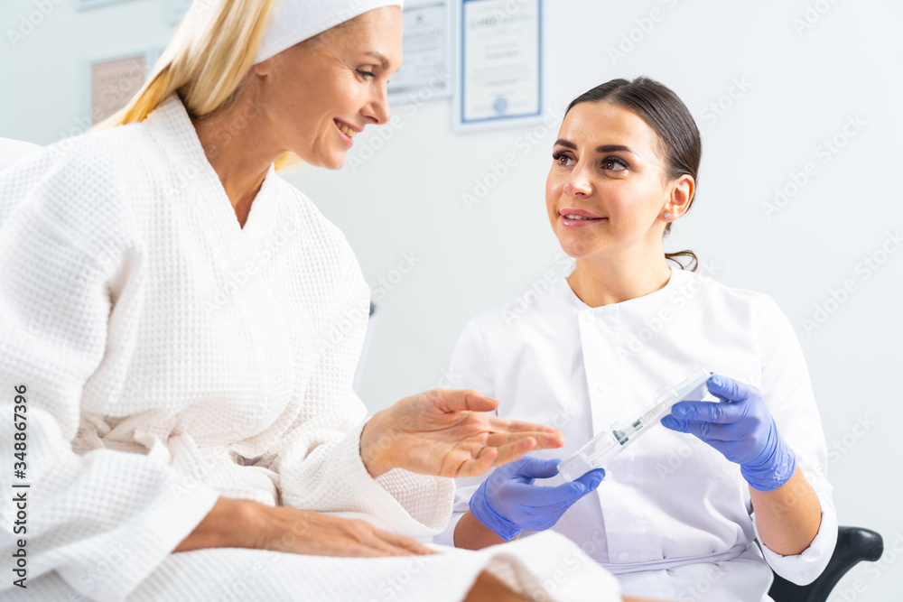 Fototapeta premium Smiling mature patient pointing at a beauty product