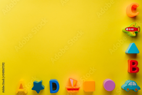 Top view on children s toys on a yellow background. Children's toys on the table. concept for advertising toys for children. Copy space children's toy.
