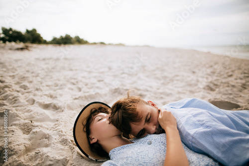 Young couple lying on the sand on the beach and kissing. Holidays at sea © Yevhenii Kukulka