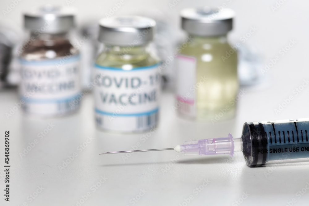 Injection syringe with vaccine bottles and medicine in selective focus for treatment of Coronavirus patients Injection syringe with vaccine bottles and medicine in selective focus for treatment of Coronavirus patients