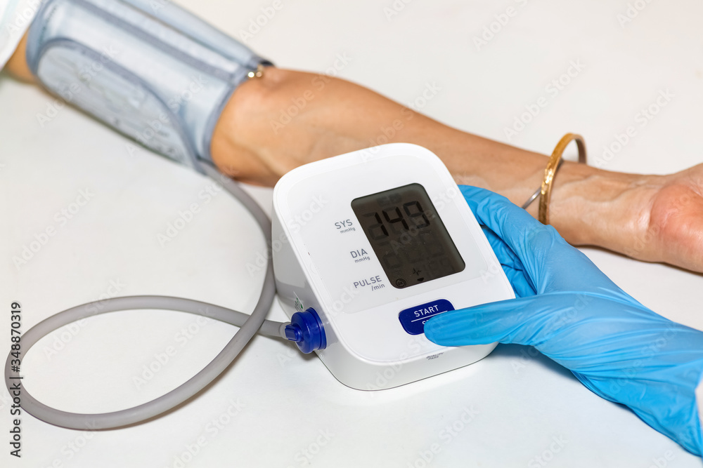 Medical examiner use portable monitoring device to measure blood pressure and heart rate of female patient Medical examiner use portable monitoring device to measure blood pressure and heart rate of female patient
