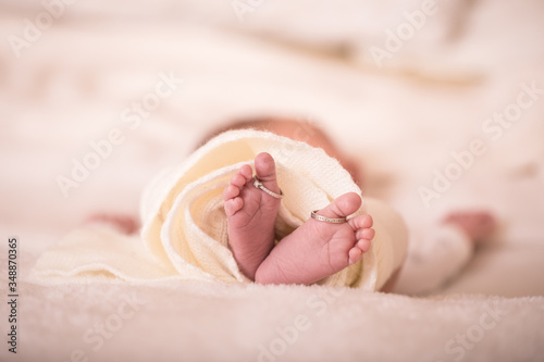 Babies foot taken closeup with two rings. Closeup of newborn baby feet with wedding rings. The concept of the family.