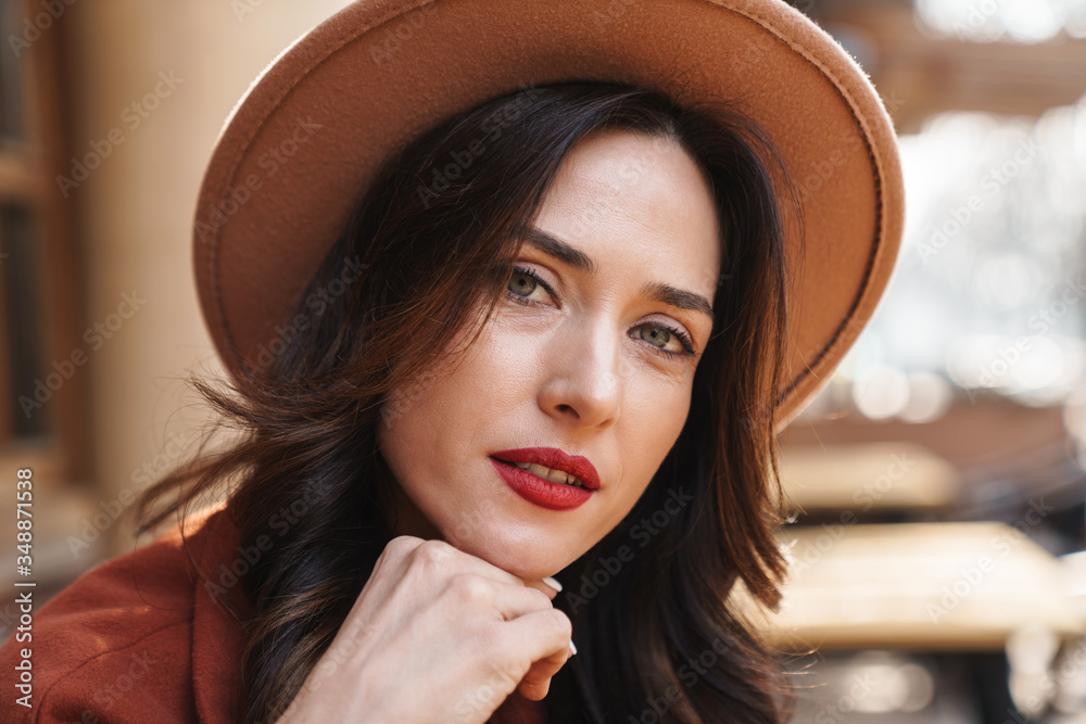 Image of serious adult woman looking at camera while sitting in cafe Image of serious adult woman looking at camera while sitting in cafe