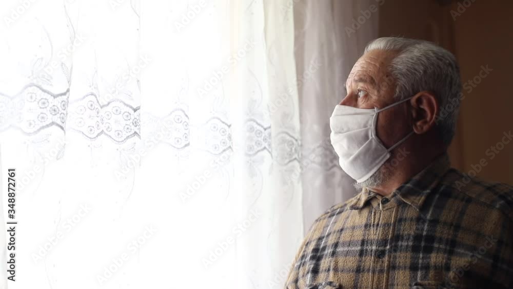 Senior man with heavy breathing in a mask at home. Pamdemia of the coronavirus