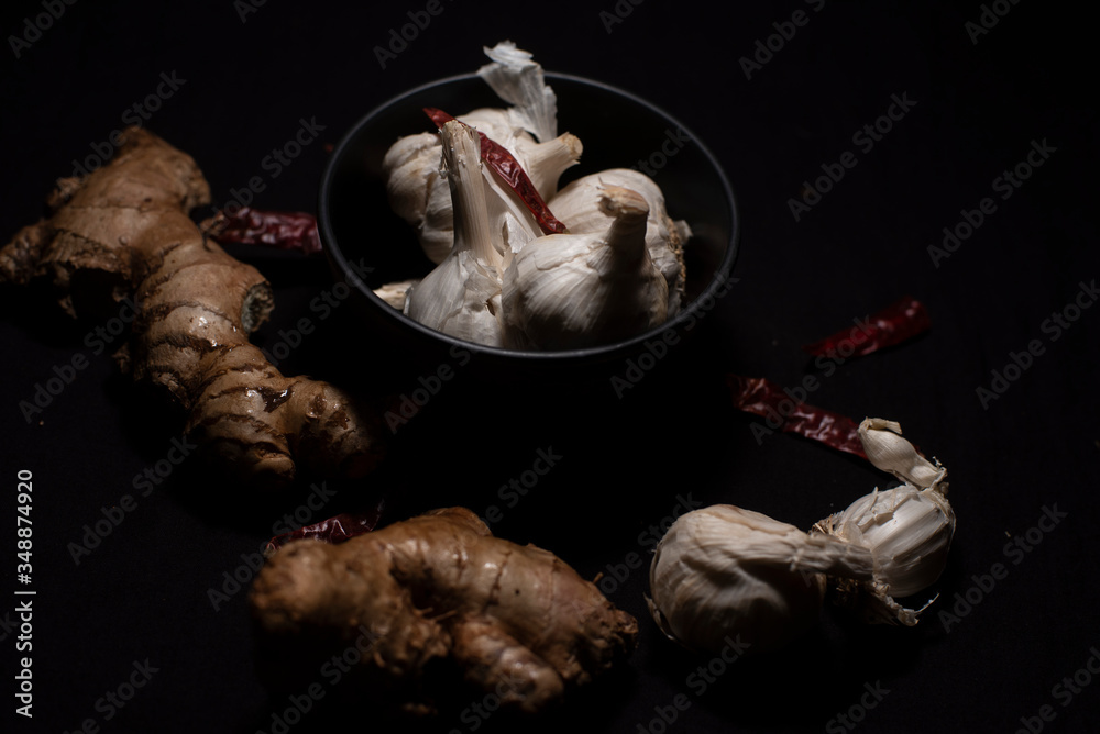 A collection of garlic and ginger in dark copy space background. Food and product photography