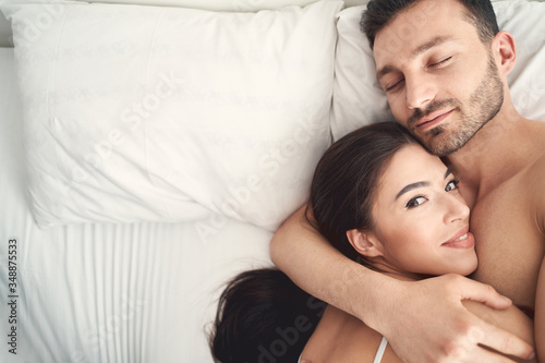 Young man hugging his wife during sleep