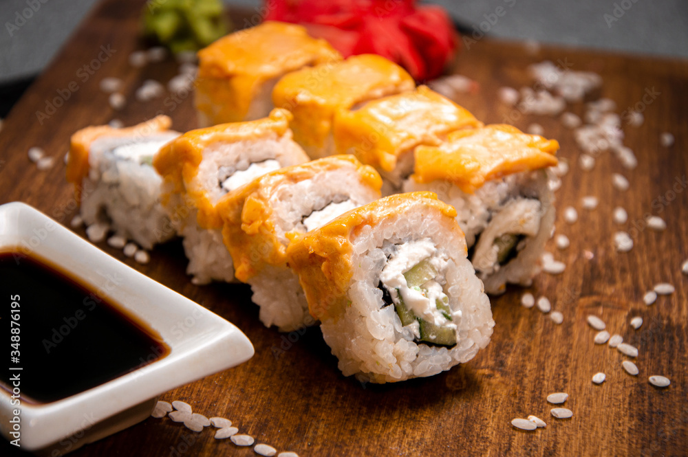 Rolls with curd and cream cheese. Wooden tray. Cup with soy sauce Rolls with curd and cream cheese. Wooden tray. Cup with soy sauce