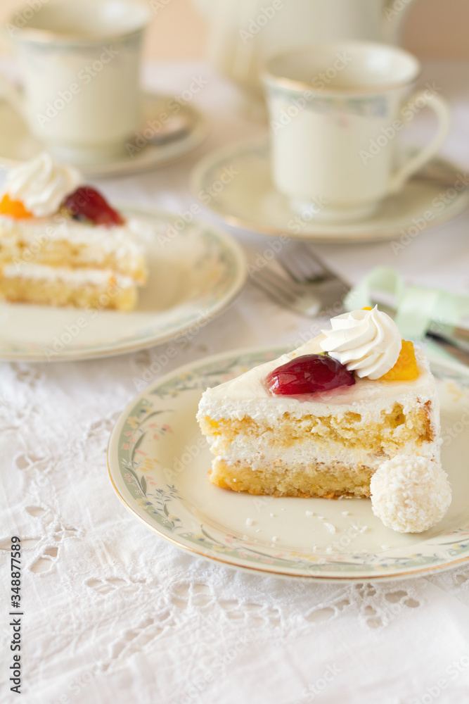 Slice of cake with cream and fruits on white background. Tea time. Selective focus Slice of cake with cream and fruits on white background. Tea time. Selective focus