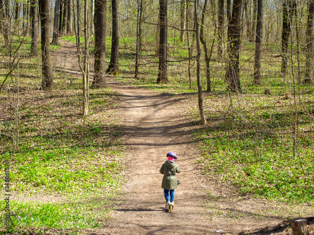 Obraz premium child in the woods on a scooter