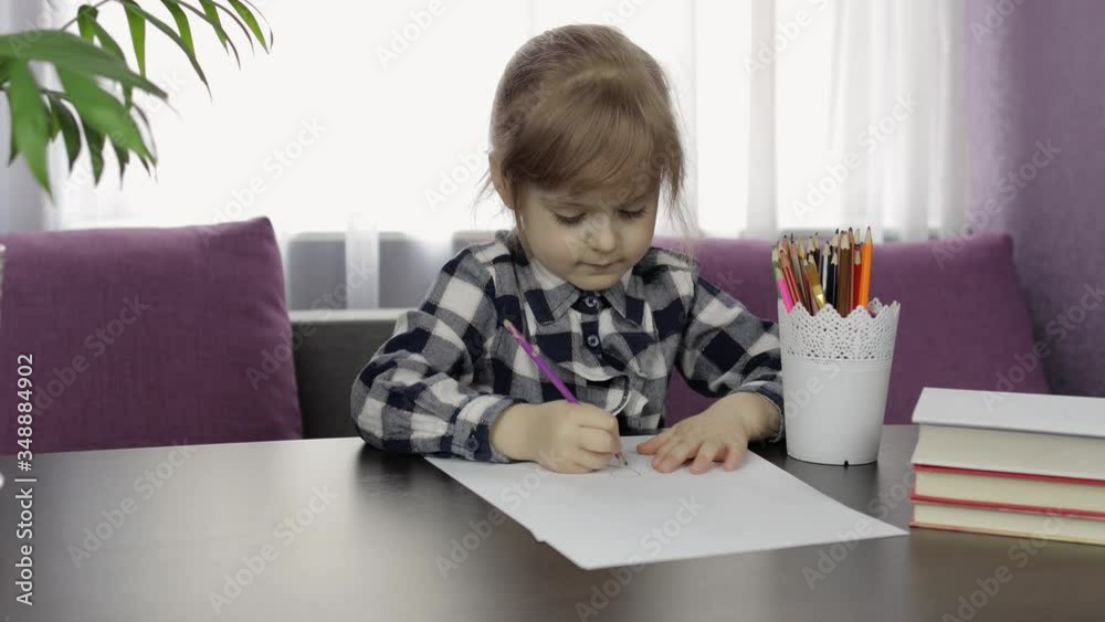 Cute child girl studying drawing picture with pencil at home. Distance education Cute child girl studying drawing picture with pencil at home. Distance education