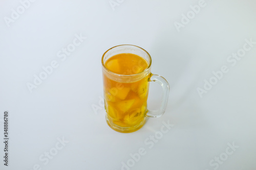 a glass of Kolak isolated on white background. Kolak is an Indonesian dessert based on palm sugar or coconut sugar, coconut milk, and pandanus leaf contains banana and pumpkins or sweet potatoes,