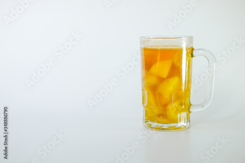 a glass of Kolak isolated on white background. Kolak is an Indonesian dessert based on palm sugar or coconut sugar, coconut milk, and pandanus leaf contains banana and pumpkins or sweet potatoes, photo