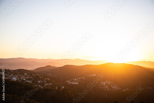 Beautiful sunset with sun rays with hills silhouette