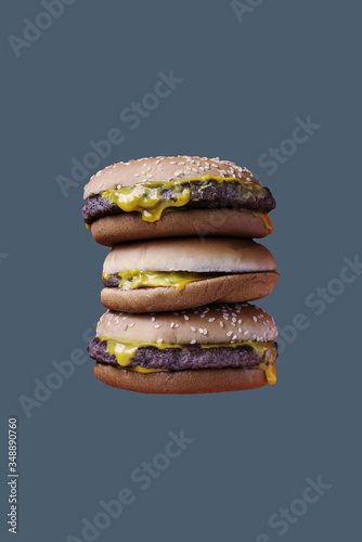 Three hamburgers on the grey background. Fast food concept. Copy space. Place for text and design.
