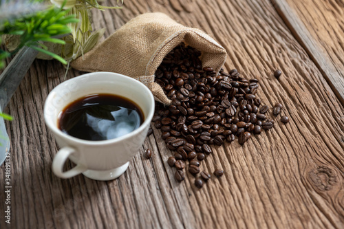 Coffee cup and coffee beans on a wooden table.