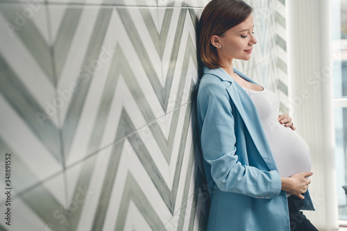 Free Download Charming pregnant woman standing by the wall - GFXLoad