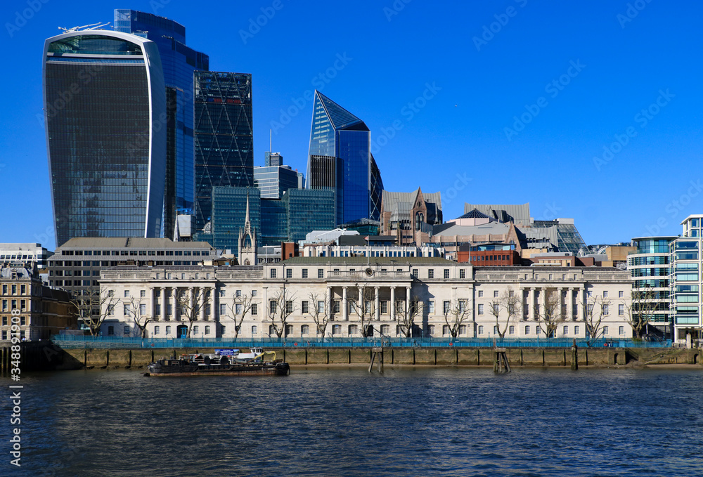 A view of the City of London financial district from the south bank of the river Thames on a sunny afternoon. London, United Kingdom.