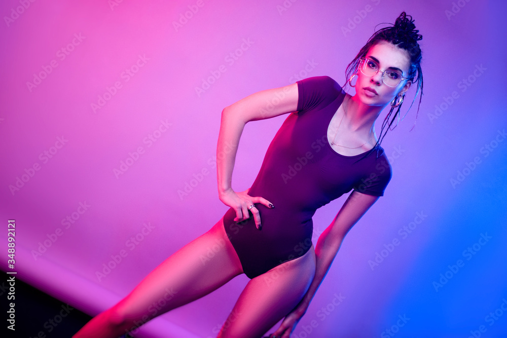 slender girl on a white background of neon color posing in a bodysuit
