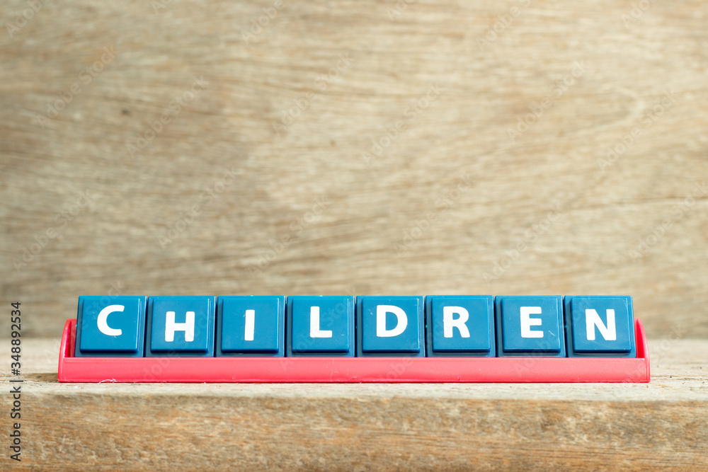 Tile letter on red rack in word children on wood background Tile letter on red rack in word children on wood background