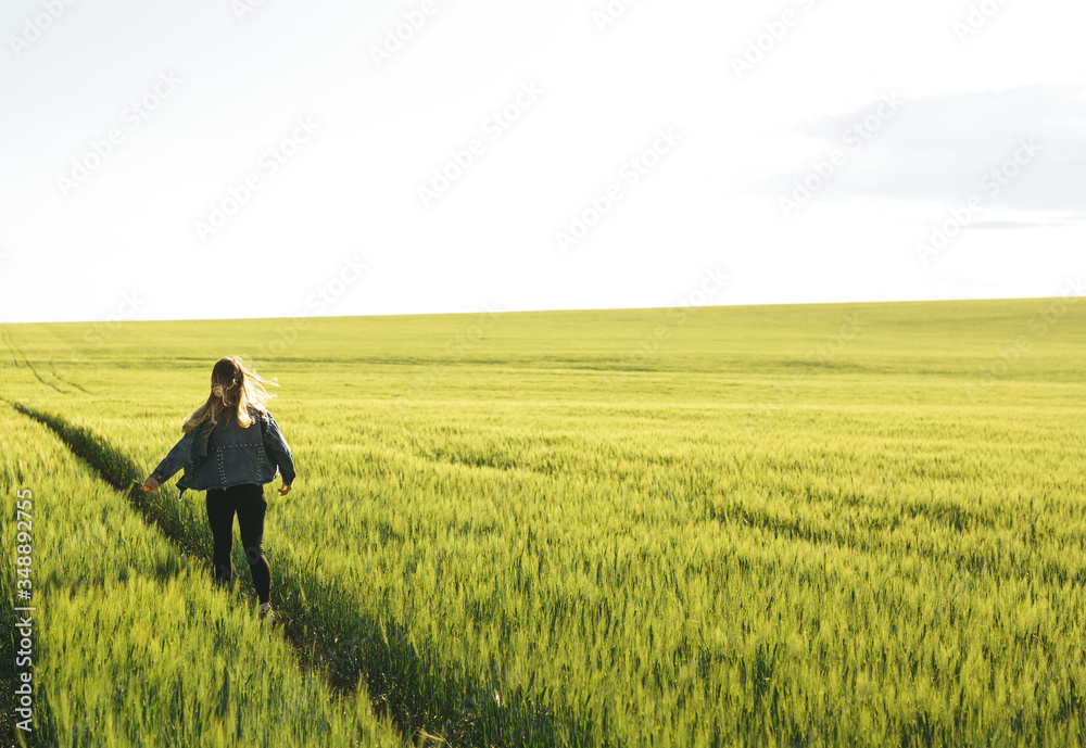 Young blonde girl running through the green wheat field. Concept of travel, inspiration, freedom, lifestyle.
Young blonde girl running through the green wheat field. Concept of travel, inspiration, freedom, lifestyle.
