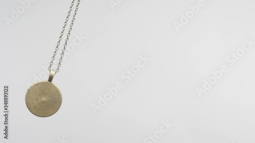 hypnotic pendulum swinging on white background close-up. photo