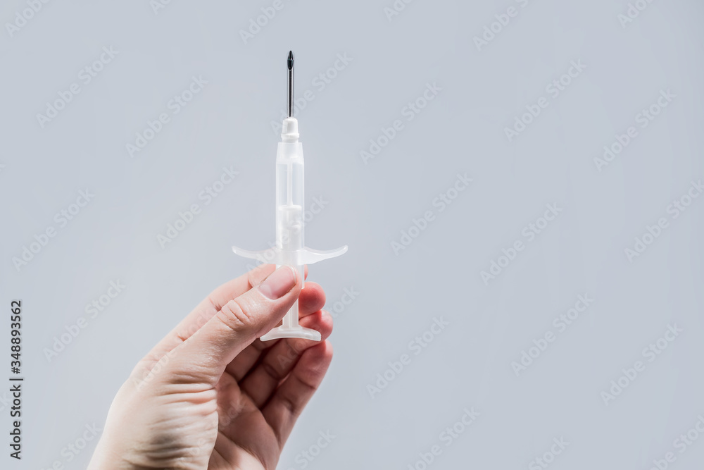 syringe with a microchip in his hand on a light background close syringe with a microchip in his hand on a light background close