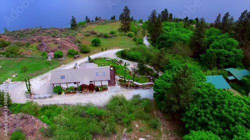 Large beautiful home horse ranch on the side of the mountain near large Lake Chelan in Eastern Washington. Home exteriors and green landscaping. 
