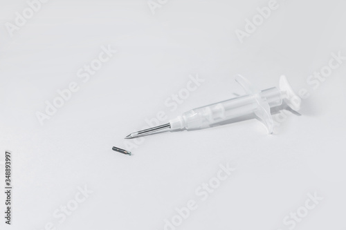 syringe with a microchip on a light background, no one, close up