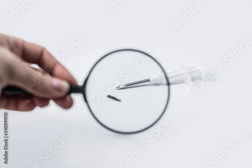 syringe with a microchip on a light background, nobody, close up