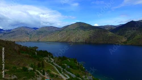 Large beautiful home horse ranch on the side of the mountain near large Lake Chelan in Eastern Washington. Home exteriors and green landscaping. 
