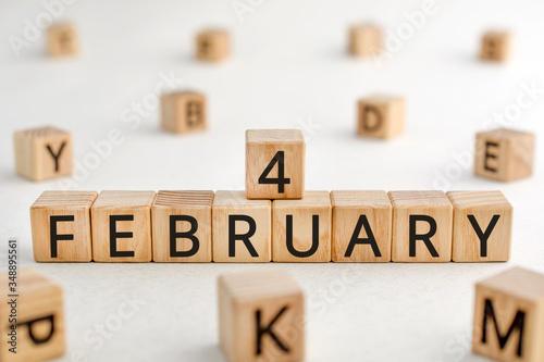 February 4 - from wooden blocks with letters, important date concept, white background random letters around