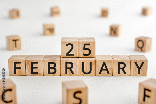 February 25 - from wooden blocks with letters, important date concept, white background random letters around