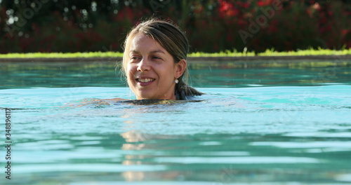 Casual candid woman at the swimming pool water enjoying vacations