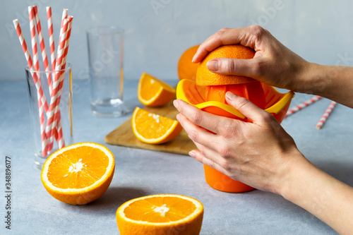 woman make orange juice home. female hands. haelthy food photo