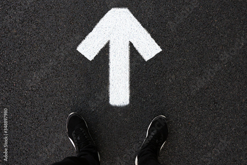 A man is standing on the road. Forward arrow
