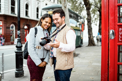 Canvas Print Happy travelling couple reviewing photos in London, UK