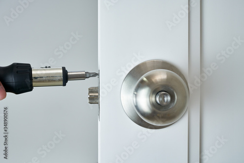 locksmith concept with screwdriver and silver handle and white door