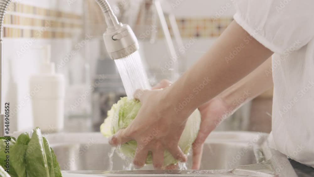 Close-up of hand Asian women wash vegetable in the kitchen and preparation for food lettuce at home morning time	
